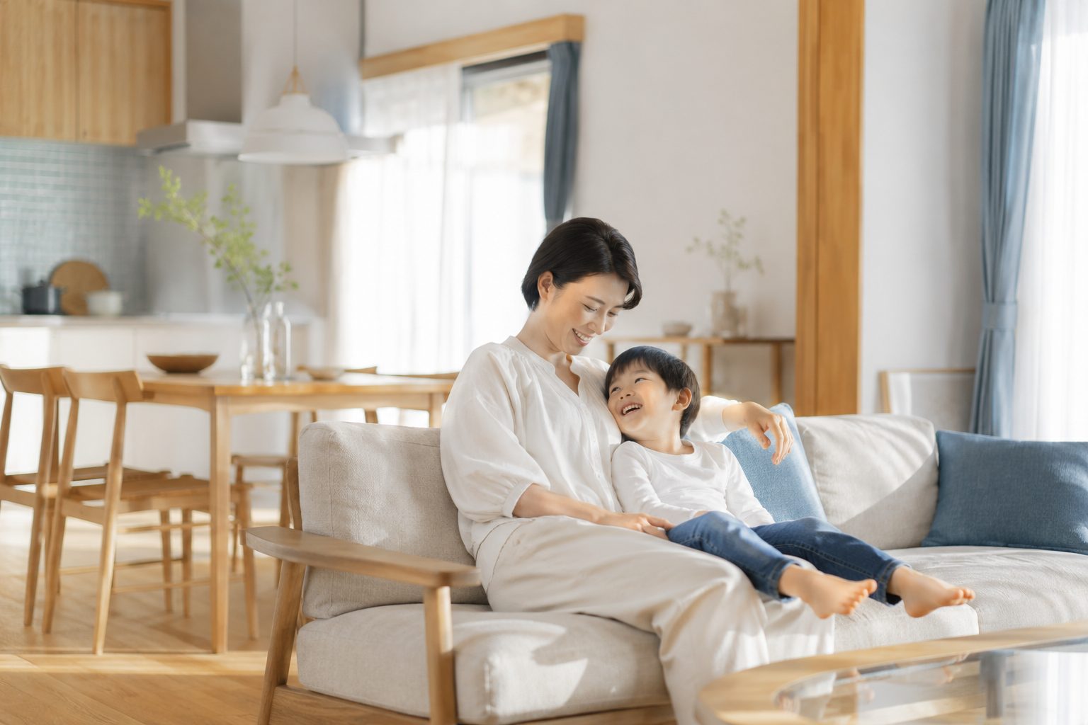朝の光が差す清潔なリビングでくつろぐ家族